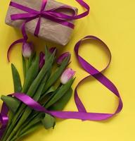 bellissimo primavera tulipani, regalo scatola e nastro otto sagomato su giallo sfondo. concetto di san valentino giorno, Da donna giorno marzo otto, madri giorno. foto