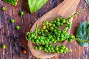 superiore Visualizza di verde un' mazzo di fresco grani di pepe o spezie per cucinando nel un' di legno cucchiaio foto