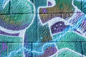 frammento di graffiti disegni. il vecchio parete decorato con dipingere macchie nel il stile di strada arte cultura. colorato sfondo struttura nel freddo toni foto