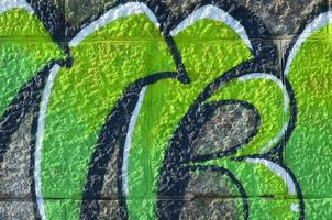 frammento di graffiti disegni. il vecchio parete decorato con dipingere macchie nel il stile di strada arte cultura. colorato sfondo struttura nel verde toni foto