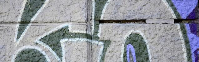 frammento di graffiti disegni. il vecchio parete decorato con dipingere macchie nel il stile di strada arte cultura. colorato sfondo struttura nel viola toni foto