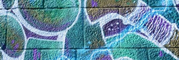 frammento di graffiti disegni. il vecchio parete decorato con dipingere macchie nel il stile di strada arte cultura. colorato sfondo struttura nel freddo toni foto