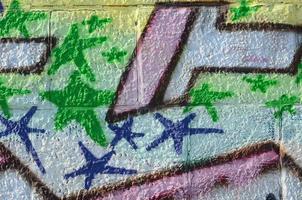 frammento di graffiti disegni. il vecchio parete decorato con dipingere macchie nel il stile di strada arte cultura. colorato sfondo struttura nel verde toni foto