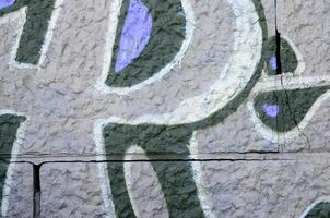 frammento di graffiti disegni. il vecchio parete decorato con dipingere macchie nel il stile di strada arte cultura. colorato sfondo struttura nel viola toni foto