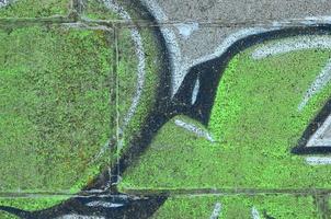 frammento di graffiti disegni. il vecchio parete decorato con dipingere macchie nel il stile di strada arte cultura. colorato sfondo struttura nel verde toni foto