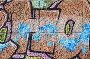 frammento di graffiti disegni. il vecchio parete decorato con dipingere macchie nel il stile di strada arte cultura. colorato sfondo struttura nel caldo toni foto