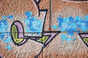 frammento di graffiti disegni. il vecchio parete decorato con dipingere macchie nel il stile di strada arte cultura. colorato sfondo struttura nel caldo toni foto