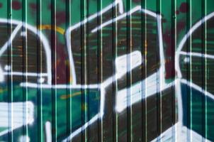 frammento di graffiti disegni. il vecchio parete decorato con dipingere macchie nel il stile di strada arte cultura. colorato sfondo struttura nel verde toni foto