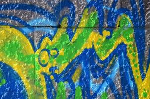 frammento di graffiti disegni. il vecchio parete decorato con dipingere macchie nel il stile di strada arte cultura. colorato sfondo struttura nel verde toni foto