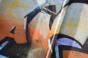 frammento di graffiti disegni. il vecchio parete decorato con dipingere macchie nel il stile di strada arte cultura. colorato sfondo struttura nel caldo toni foto