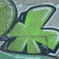 frammento di graffiti disegni. il vecchio parete decorato con dipingere macchie nel il stile di strada arte cultura. colorato sfondo struttura nel verde toni foto