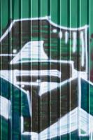 frammento di graffiti disegni. il vecchio parete decorato con dipingere macchie nel il stile di strada arte cultura. colorato sfondo struttura nel verde toni foto