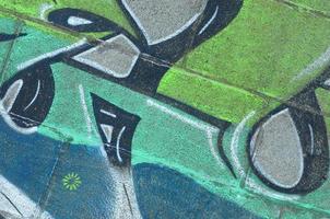 frammento di graffiti disegni. il vecchio parete decorato con dipingere macchie nel il stile di strada arte cultura. colorato sfondo struttura nel verde toni foto