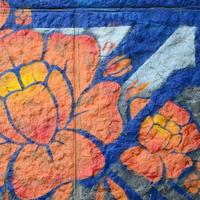 frammento di graffiti disegni. il vecchio parete decorato con dipingere macchie nel il stile di strada arte cultura. arancia fiore foto