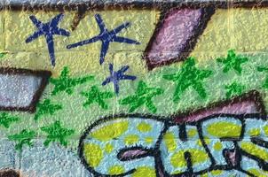 frammento di graffiti disegni. il vecchio parete decorato con dipingere macchie nel il stile di strada arte cultura. colorato sfondo struttura nel verde toni foto