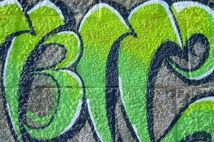 frammento di graffiti disegni. il vecchio parete decorato con dipingere macchie nel il stile di strada arte cultura. colorato sfondo struttura nel verde toni foto