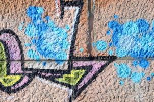 frammento di graffiti disegni. il vecchio parete decorato con dipingere macchie nel il stile di strada arte cultura. colorato sfondo struttura nel caldo toni foto