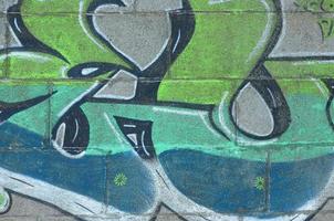 frammento di graffiti disegni. il vecchio parete decorato con dipingere macchie nel il stile di strada arte cultura. colorato sfondo struttura nel verde toni foto