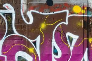 frammento di graffiti disegni. il vecchio parete decorato con dipingere macchie nel il stile di strada arte cultura. colorato sfondo struttura nel caldo toni foto