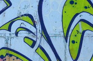 frammento di graffiti disegni. il vecchio parete decorato con dipingere macchie nel il stile di strada arte cultura. colorato sfondo struttura nel verde toni foto