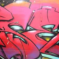 frammento di graffiti disegni. il vecchio parete decorato con dipingere macchie nel il stile di strada arte cultura. colorato sfondo struttura nel caldo toni foto