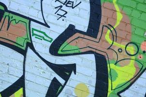 frammento di graffiti disegni. il vecchio parete decorato con dipingere macchie nel il stile di strada arte cultura. colorato sfondo struttura nel verde toni foto