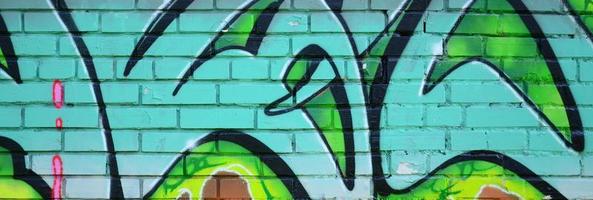 frammento di graffiti disegni. il vecchio parete decorato con dipingere macchie nel il stile di strada arte cultura. colorato sfondo struttura nel verde toni foto