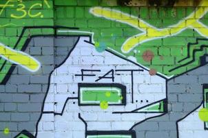 frammento di graffiti disegni. il vecchio parete decorato con dipingere macchie nel il stile di strada arte cultura. colorato sfondo struttura nel verde toni foto