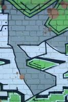 frammento di graffiti disegni. il vecchio parete decorato con dipingere macchie nel il stile di strada arte cultura. colorato sfondo struttura nel verde toni foto