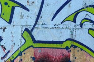 frammento di graffiti disegni. il vecchio parete decorato con dipingere macchie nel il stile di strada arte cultura. colorato sfondo struttura nel verde toni foto