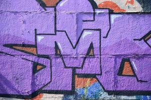 frammento di graffiti disegni. il vecchio parete decorato con dipingere macchie nel il stile di strada arte cultura. colorato sfondo struttura nel viola toni foto