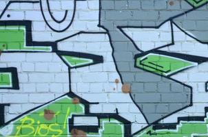 frammento di graffiti disegni. il vecchio parete decorato con dipingere macchie nel il stile di strada arte cultura. colorato sfondo struttura nel verde toni foto