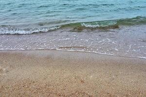 mare costa e in movimento onda a il sabbioso spiaggia per sfondo e ispirazione testo. foto