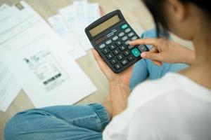 debito. donne calcolare spese con grande fatture. stressato casalinga guardare per un' modo per pagare credito carta fatture. foto