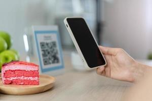 donna uso smartphone per scansione qr codice per pagare nel bar ristorante con un' digitale pagamento senza Contanti. scegliere menù e ordine accumulare sconto. e portafoglio, tecnologia, pagare in linea, credito carta, banca App foto