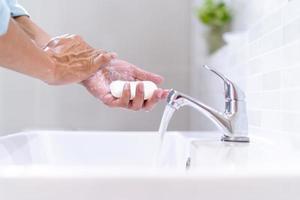 uomini lavaggio mani con sapone e pulito acqua nel davanti di il bagno Lavello per impedire il diffusione di germi. lavaggio mani con sapone. foto