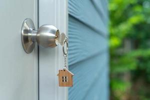 proprietario chiave per sblocco Casa è tappato in il porta. secondo mano Casa per affitto e saldi. portachiavi è soffiaggio nel il vento. mutuo per nuovo casa, acquistare, vendere, ristrutturare, investimento, proprietario, tenuta foto