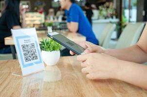 donna uso smartphone per scansione qr codice per pagare nel bar ristorante con un' digitale pagamento senza Contanti. scegliere menù e ordine accumulare sconto. e portafoglio, tecnologia, pagare in linea, credito carta, banca App foto