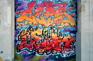 un' frammento di dettagliato graffiti di un' disegno fatto con aerosol vernici su un' parete di calcestruzzo piastrelle. sfondo Immagine di strada arte nel caldo rosso colore toni foto