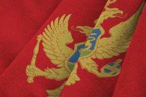 montenegro bandiera con grande pieghe agitando vicino su sotto il studio leggero al chiuso. il ufficiale simboli e colori nel bandiera foto