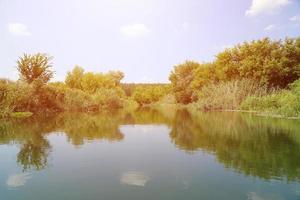 soleggiato primavera mattina su prato vicino fiume foto