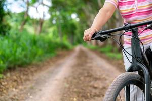 anziano attività commerciale donna, femmina, cavalcata o bicicletta montagna bicicletta nel nazione parco vicino casa cittadina per salutare esercizio nel estate fine settimana foto