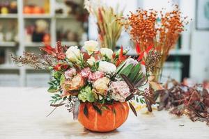 Fai da te autunno fiore preparativi mazzo nel zucca a il floristica studio foto