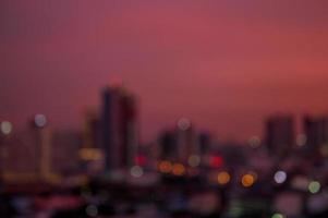 tramonto chiaro cielo sfondo prima notte al di sopra di il bokeh leggero di il città foto