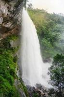 cascata grande e alto ruscello fiume montagna con scogliera pietra grotta nel il giungla tropicale foto