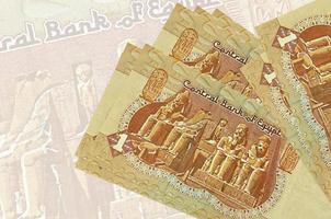 1 egiziano libbra fatture bugie nel pila su sfondo di grande semi trasparente banconota. astratto presentazione di nazionale moneta foto