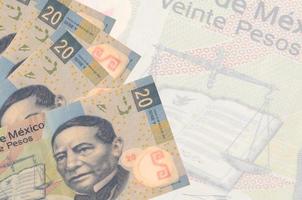 20 messicano pesos fatture bugie nel pila su sfondo di grande semi trasparente banconota. astratto attività commerciale sfondo foto