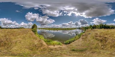 pieno senza soluzione di continuità sferico hdri 360 panorama Visualizza su erba costa di enorme lago o fiume nel soleggiato estate giorno e ventoso tempo metereologico con bellissimo nuvole nel equirettangolare proiezione, vr soddisfare foto