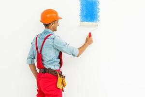 camera dipingere lavoro. pittore con un' dipingere rullo su un' bianca sfondo foto