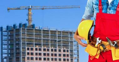 costruzione lavoratore con casco e attrezzo cintura. foto